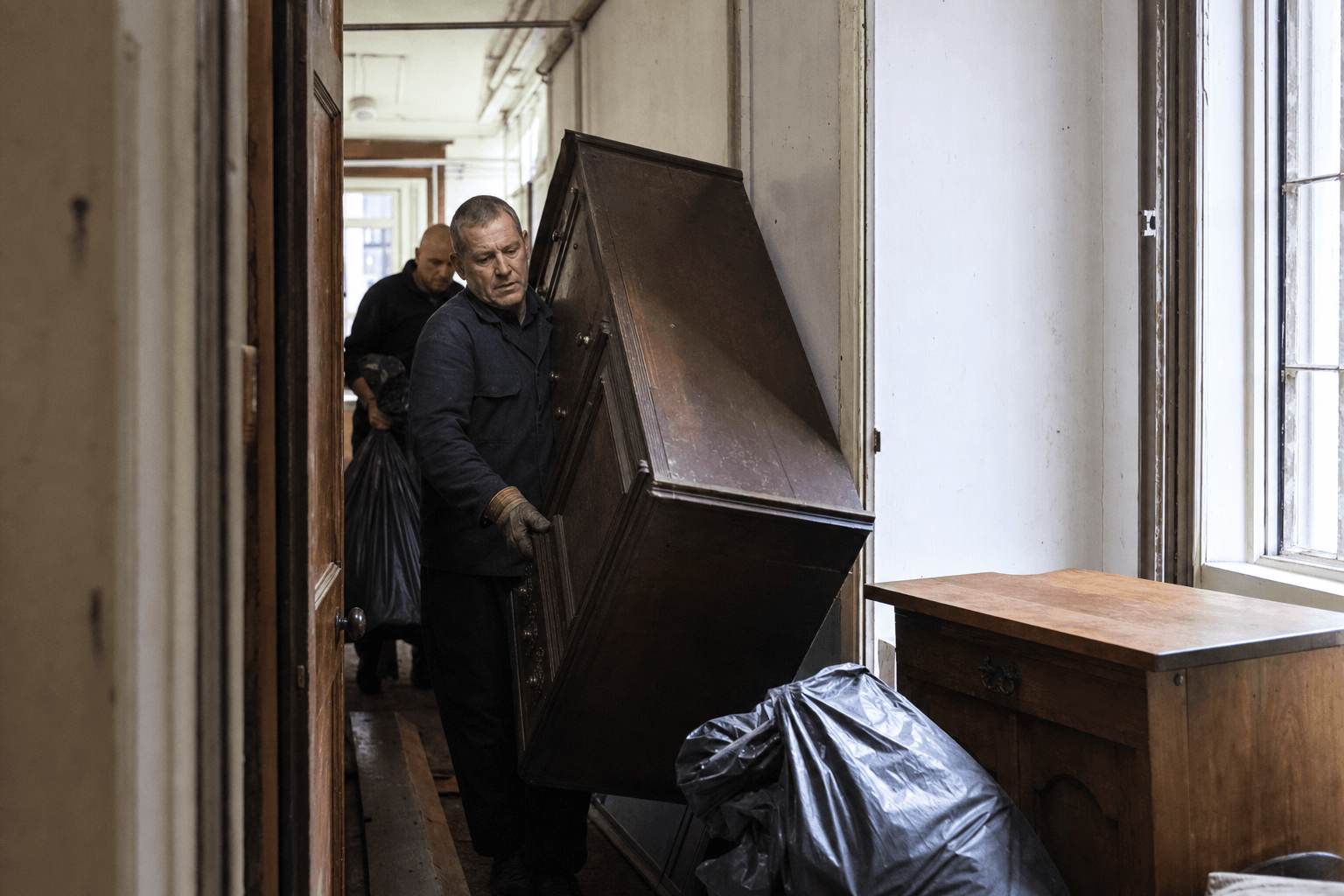 Removal team carrying furniture from a Battersea mansion block flat