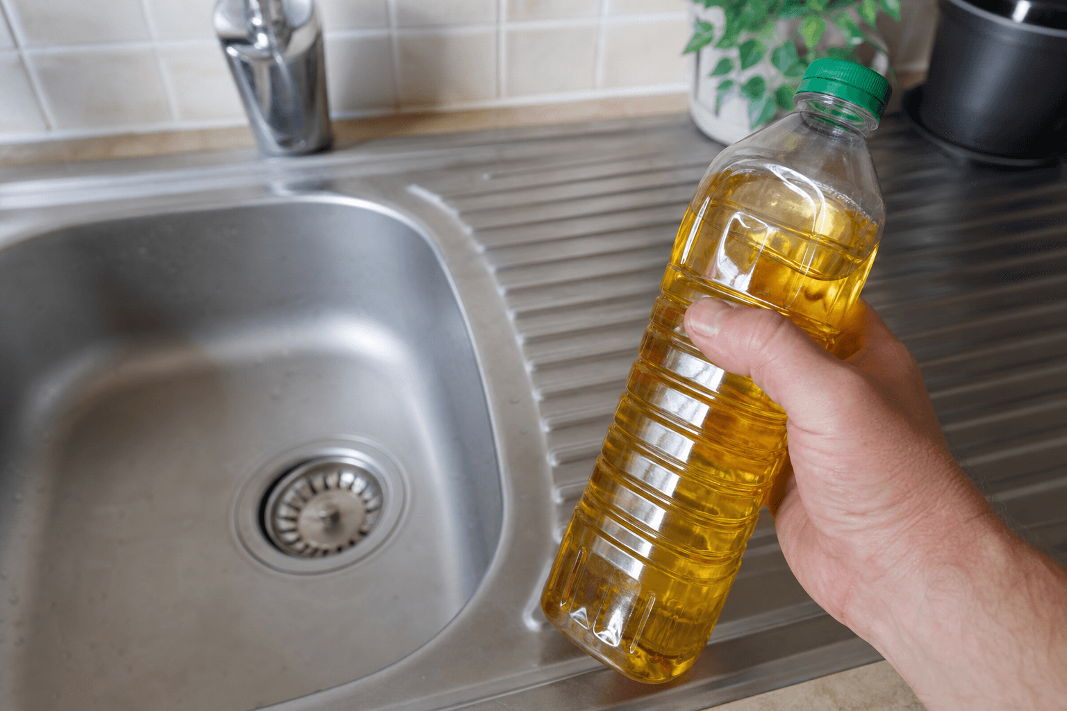Sealed bottle of used cooking oil kept away from the kitchen sink drain