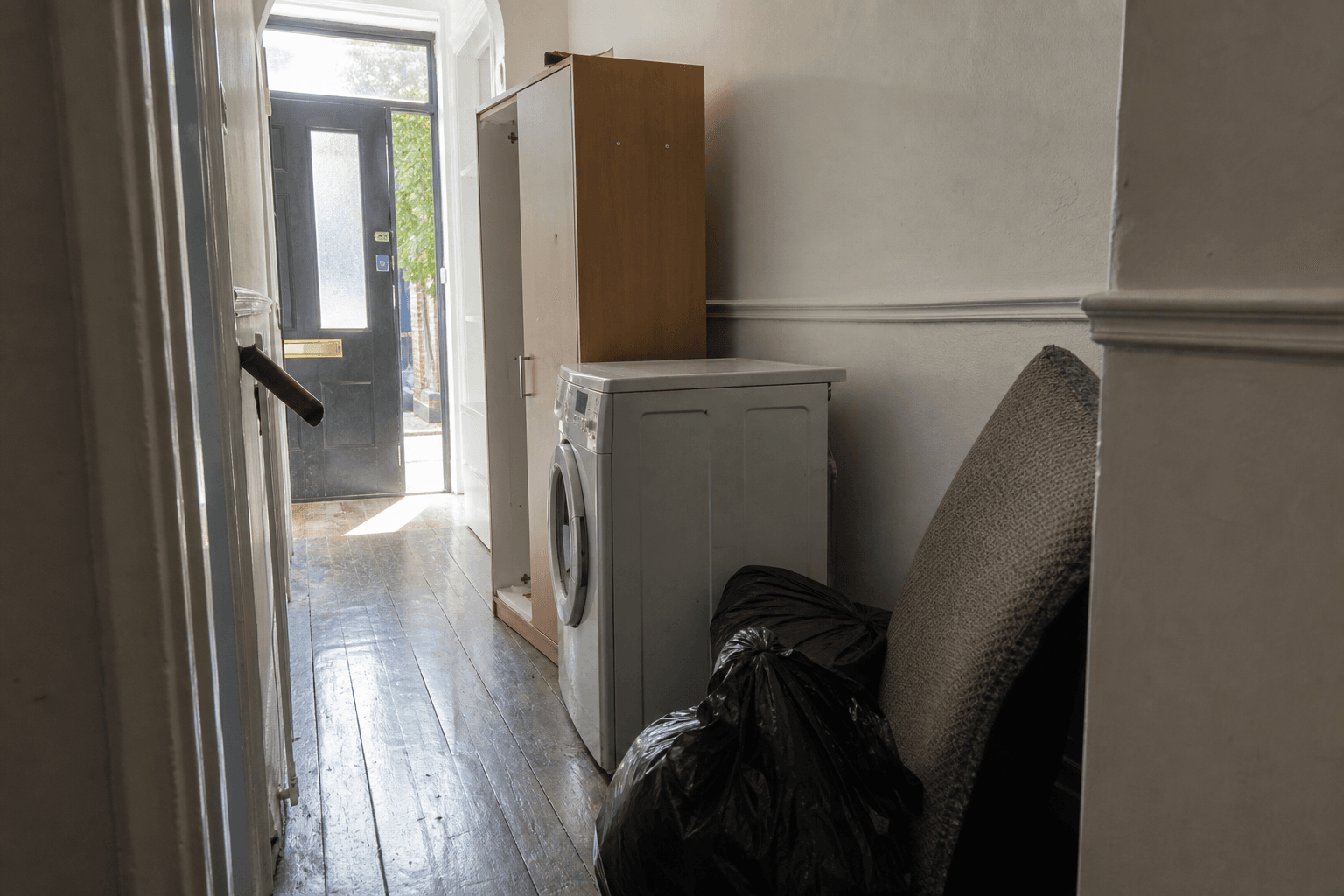 Furniture, appliances and bags in a hallway ready for same-day rubbish removal in Tooting